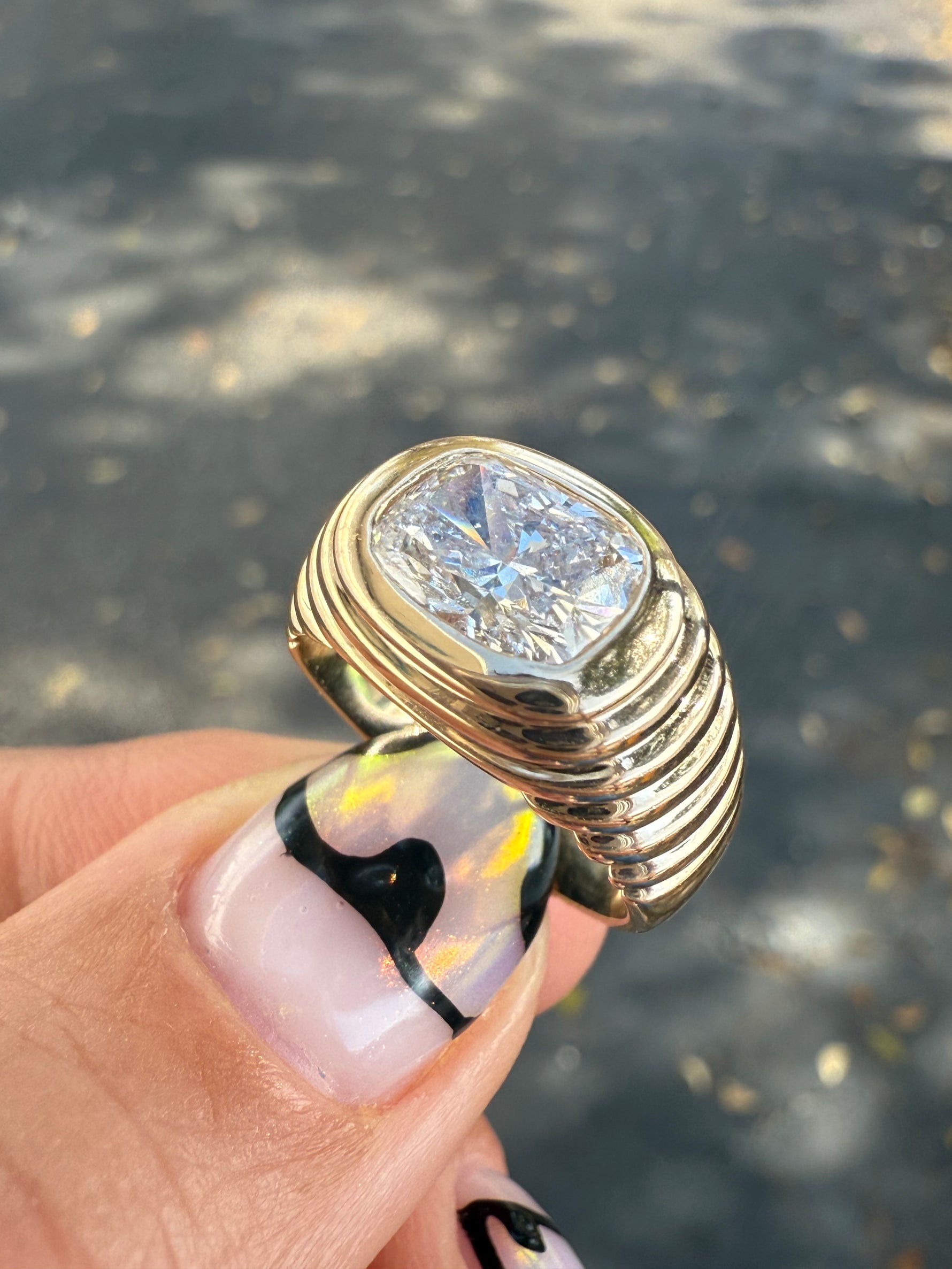 Top view of cusion cut lab diamond mounted east to west on a 14 yellow gold ring. 