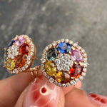 Close-up of rainbow sapphire earrings with diamond halo in rose gold