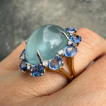 Side view of aquamarine, sapphire, and diamond cocktail ring in 14K gold