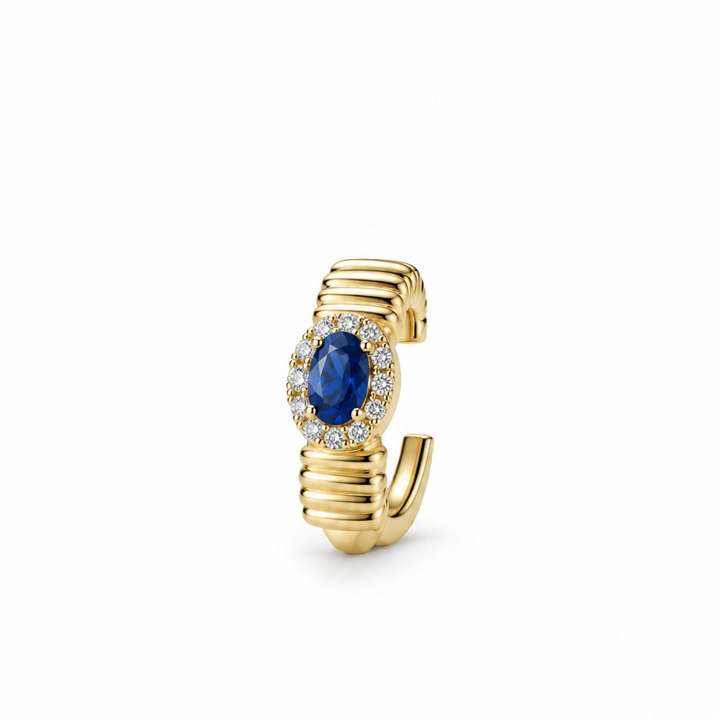 A yellow gold ear cuff featuring a central oval blue sapphire stone surrounded by a halo of small diamonds, set against a plain white background.