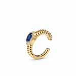 Gold ear cuff featuring a central oval blue sapphire stone surrounded by a halo of diamonds, set against a plain white background.