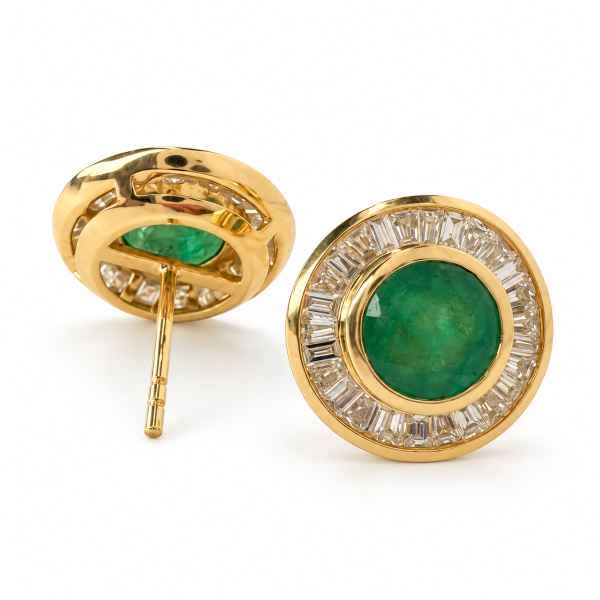 Round emerald and baguette diamond halo stud earrings in 14K yellow gold, 12.5 mm diameter, with push-back closures.