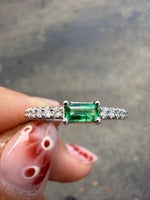 Top view of emerald and diamond ring in 14K white gold.