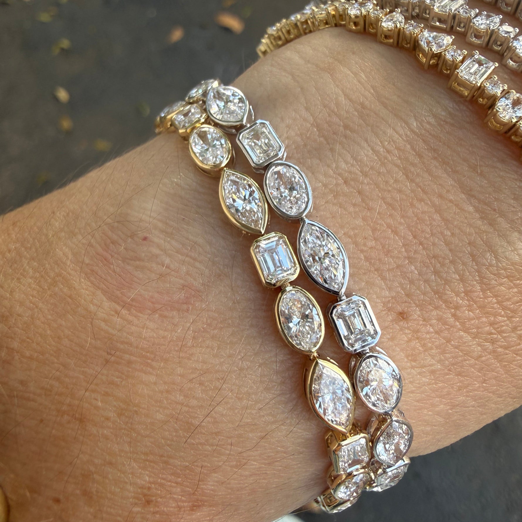 7 carat white and yellow gold multi shape lab diamond tennis bracelet on wrist.
