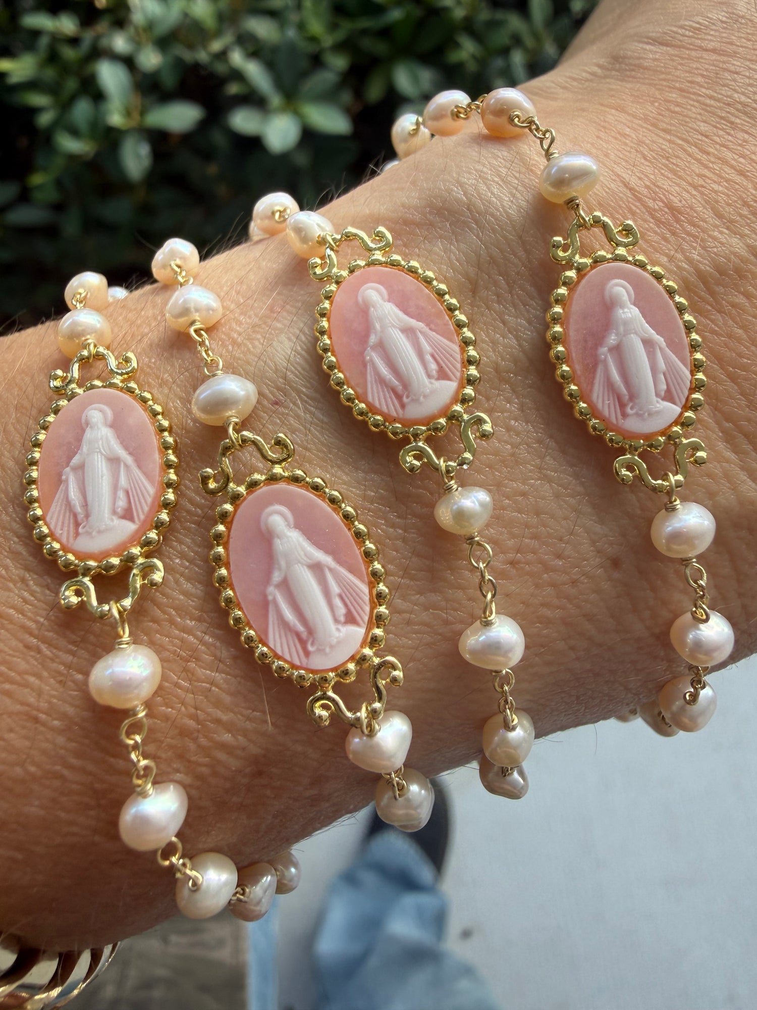Stack of bracelets in Miami style of pink milagrosa virgencita bracelets