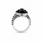 A silver-toned ring featuring a black onyx cabochon with a stylized black-and-white face design, set against a plain white background.