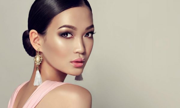 Young gorgeous asian woman in a smoky eyes style make up and tassel earrings