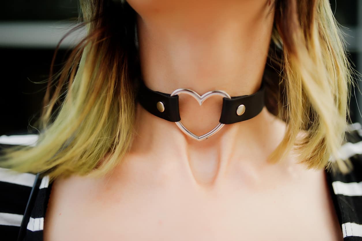Choker with heart on neck of girl.